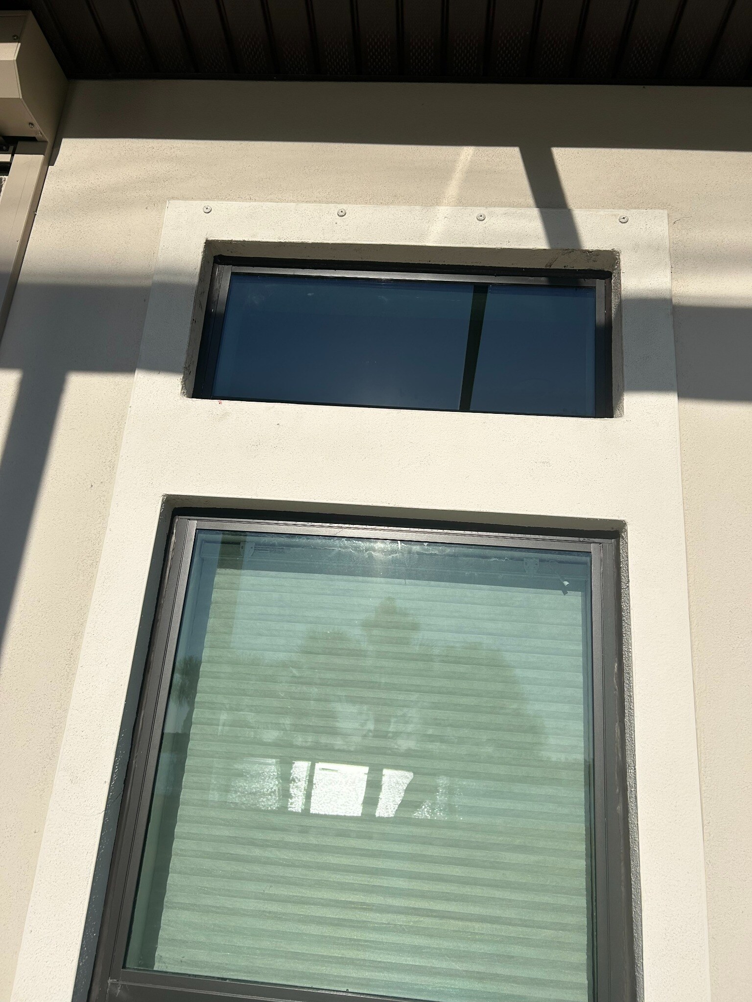 Completed replacement glass installed in dark aluminum window frame